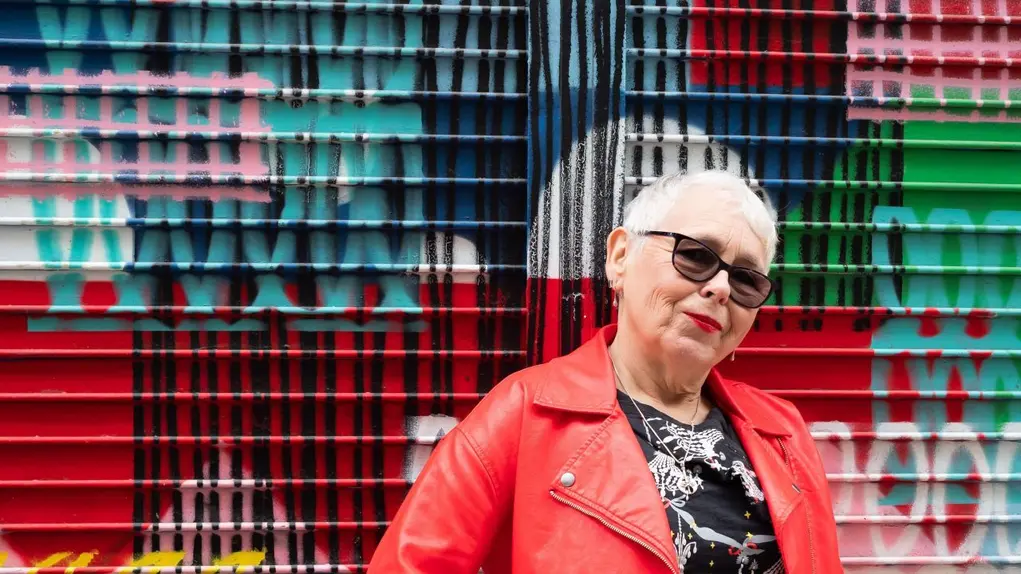 A woman in a red leather jacket and sunglasses bright colours