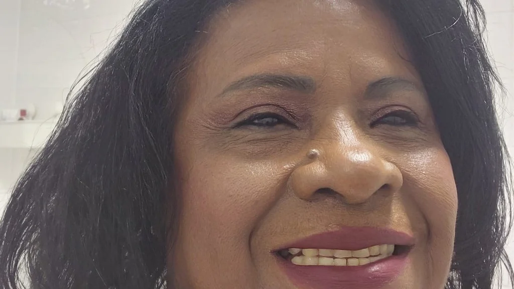 A woman smiling and looking away from the camera