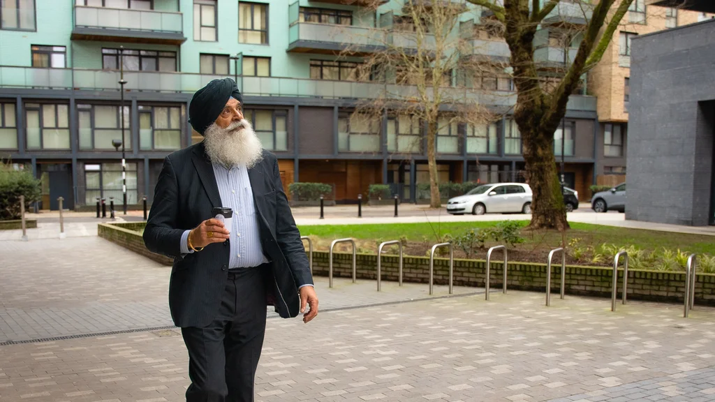 An older man walking outside in a city