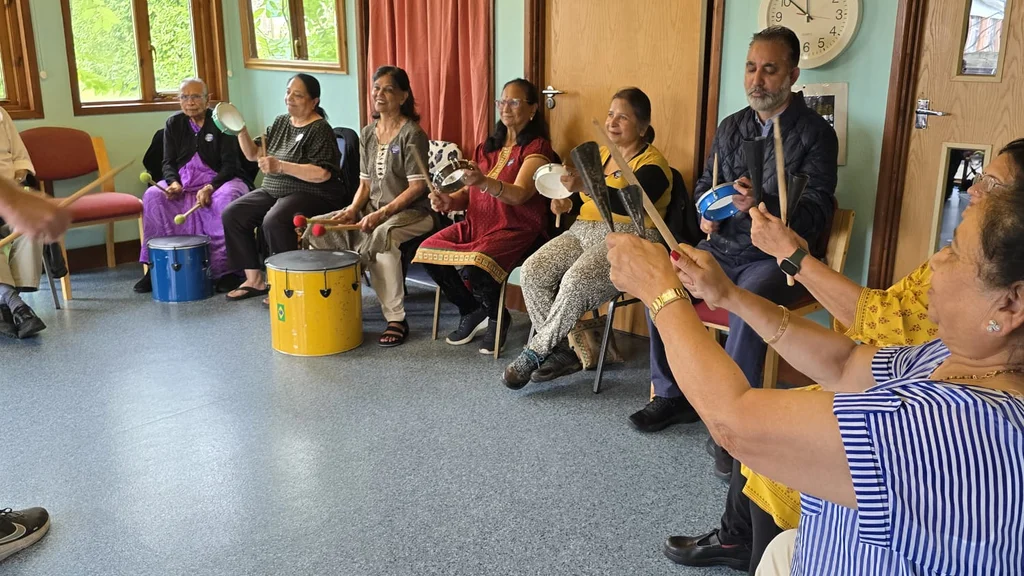A group of older people in a circle drumming